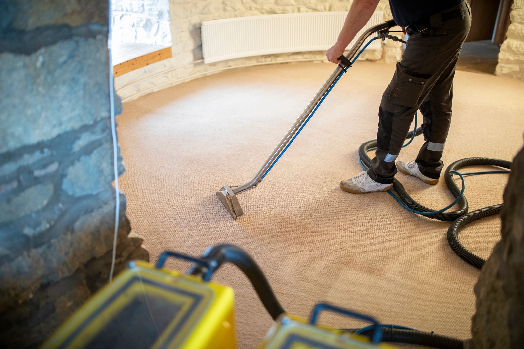 Professional cleaner vacuuming carpet in an interior room