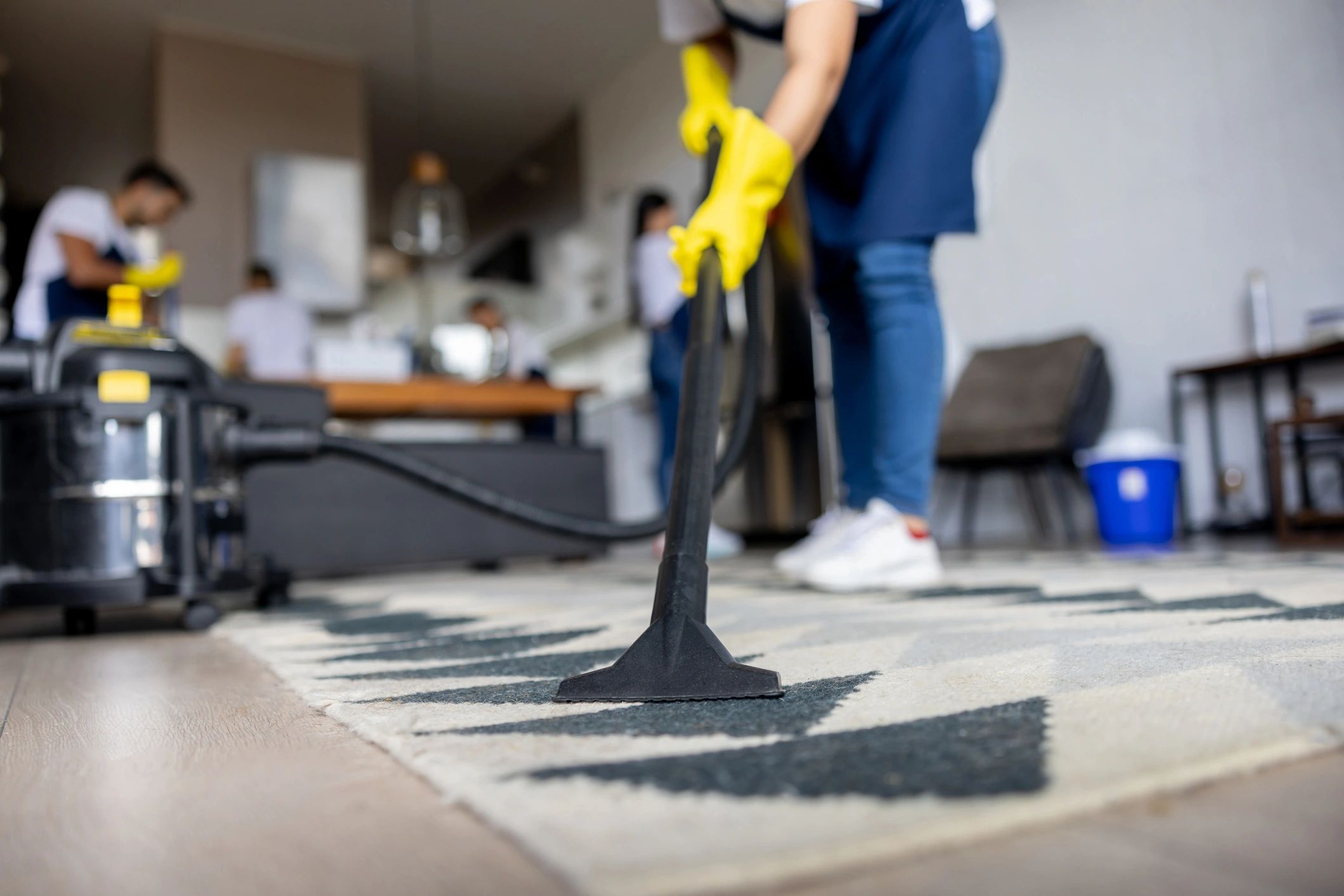 Professional cleaner vacuuming carpet in a home